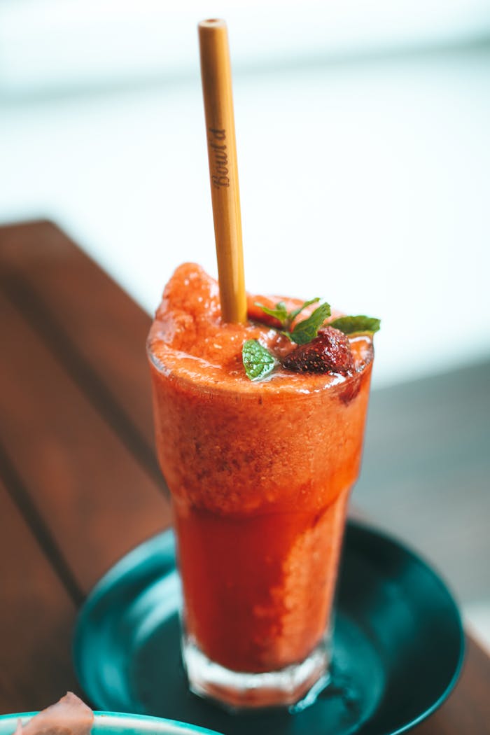 client-satisfaction-img Delicious strawberry smoothie in a glass with mint garnish and eco-friendly bamboo straw.